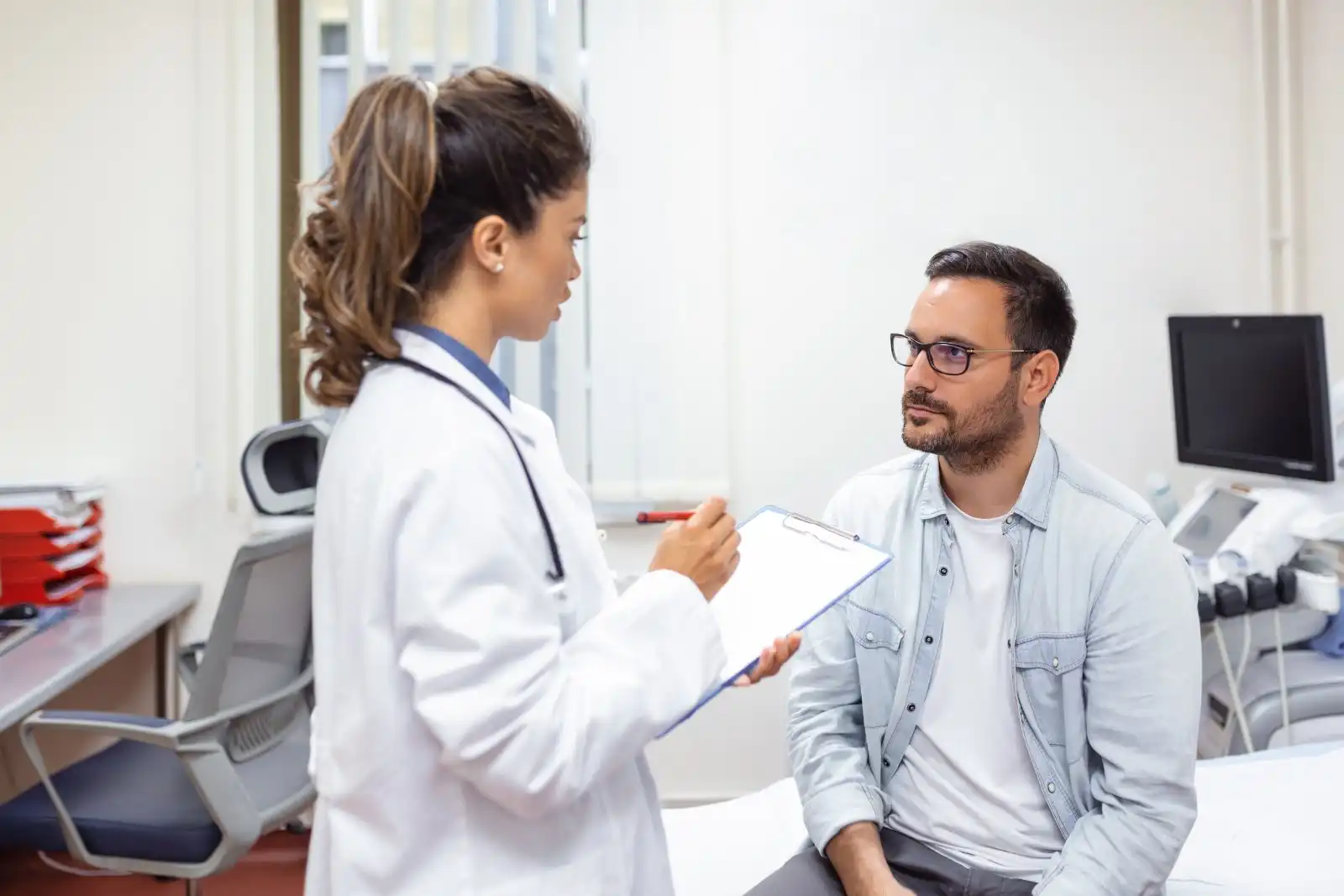 GP consulting with a patient at a desk